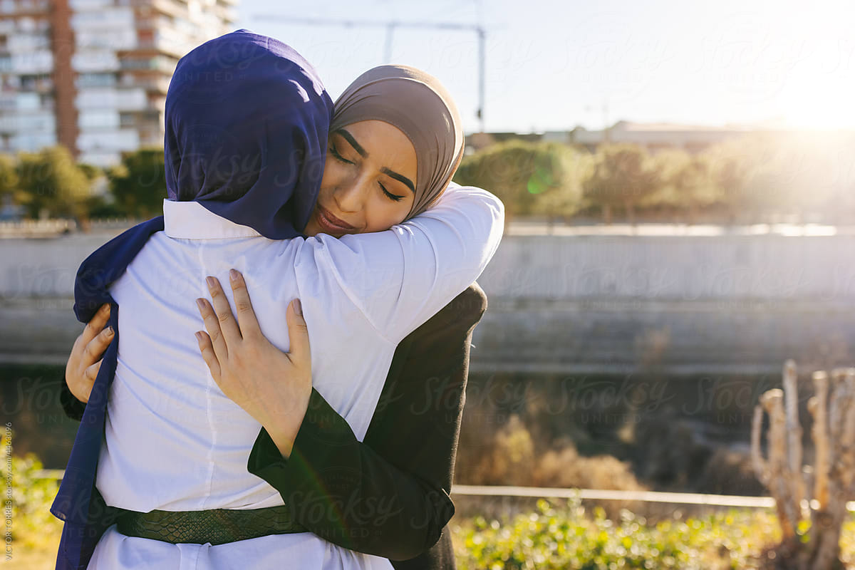 Muslim woman in hijab hugging friend