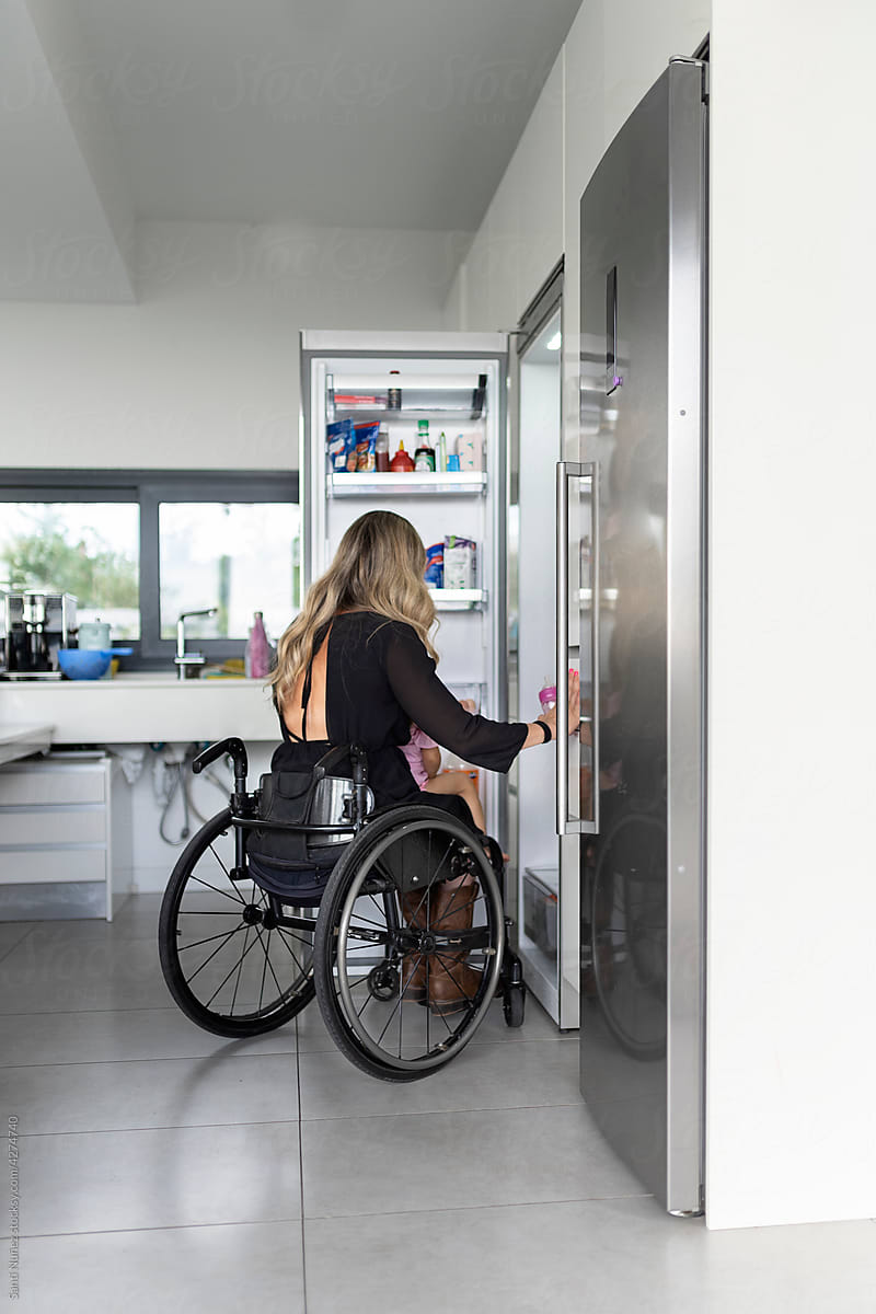 Mother in wheelchair in the kitchen with her daughter.