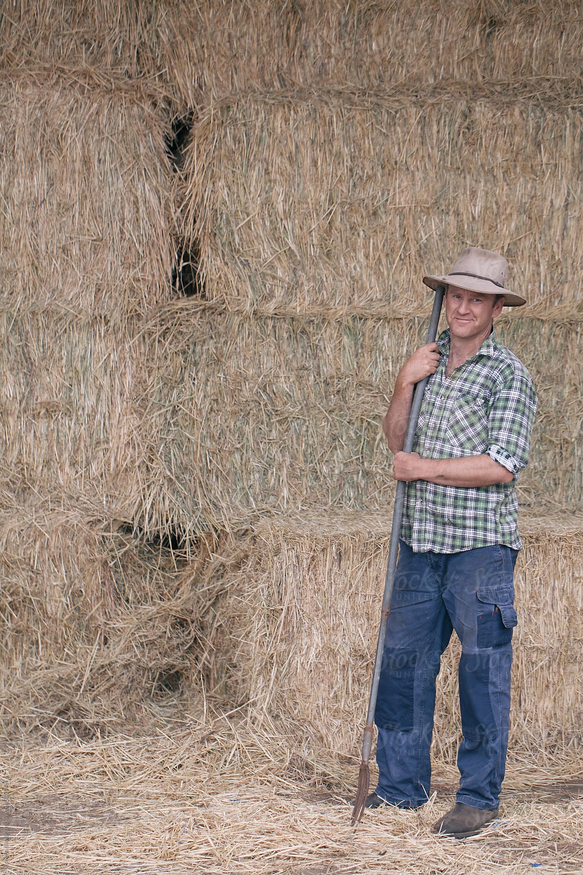 Farmer in hay barn holding a pitchfork