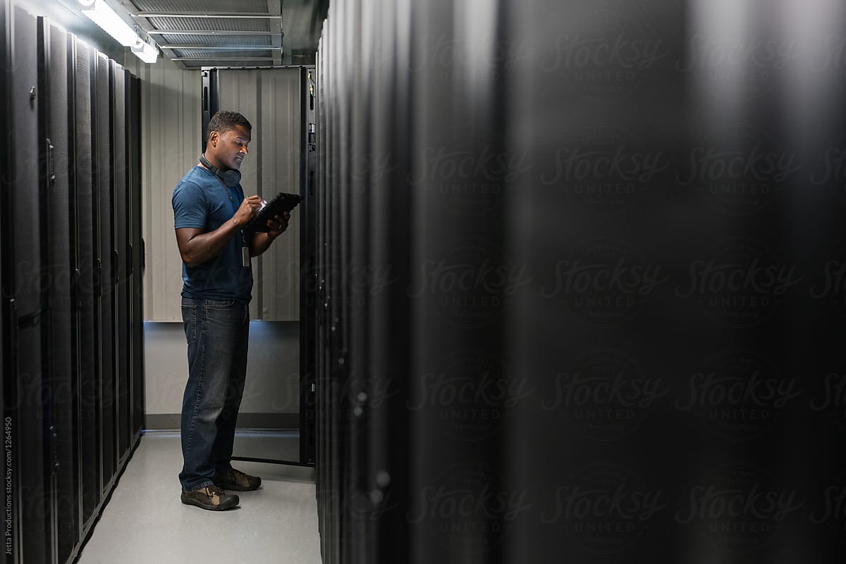 Server room technician looking at digital tablet