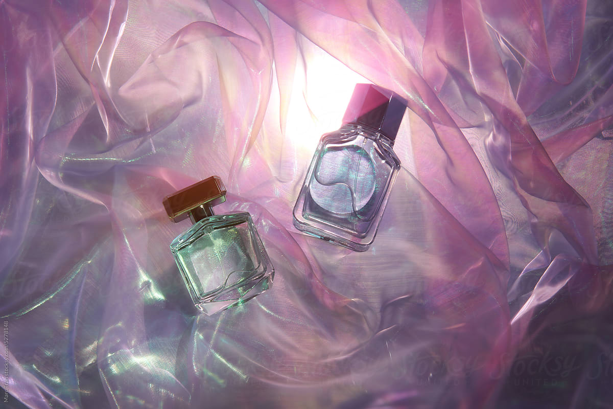 Transparent glass perfume bottles in folds of chiffon fabric
