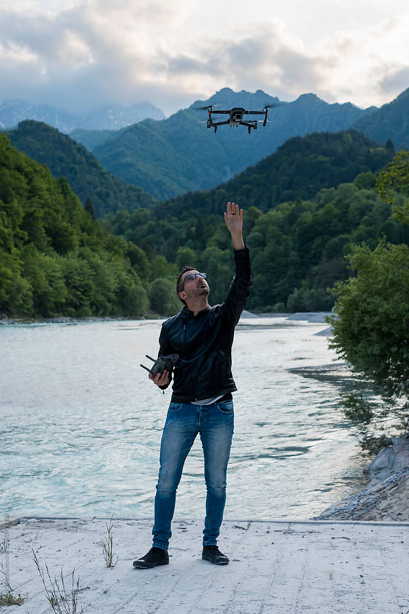 Man flying a drone to take aerial photos at the lake
