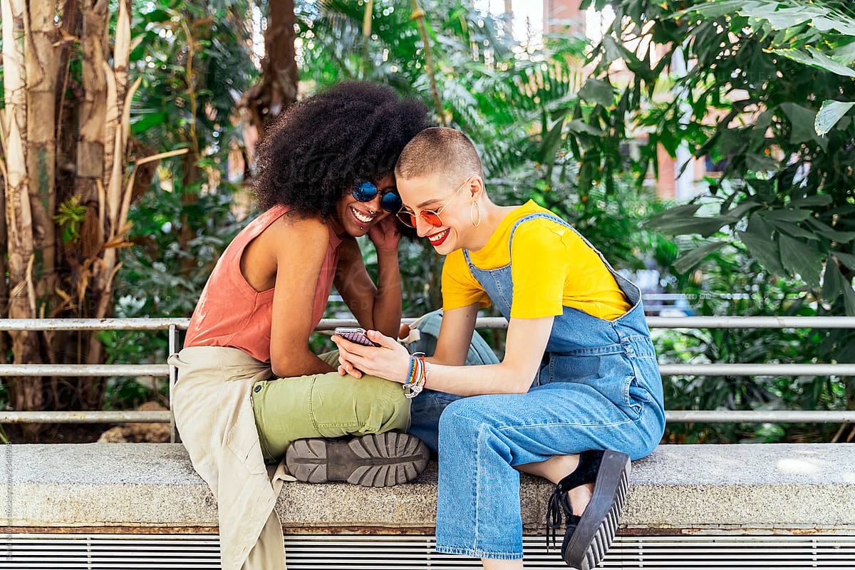 Beautiful Lesbian Couple Using A Mobile In The Street By Stocksy Contributor Santi Nuñez
