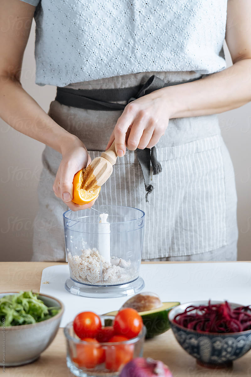 Person Preparing Food in a Blender in a Kitchen