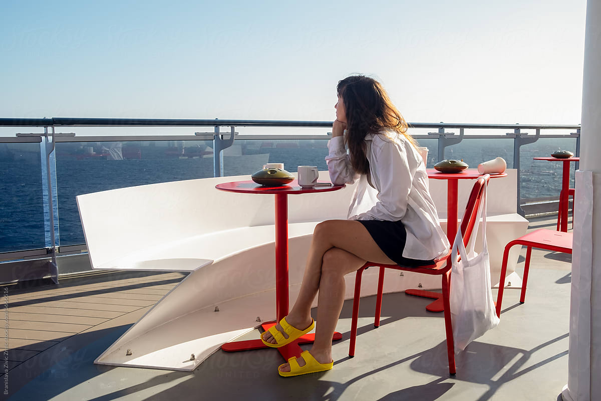 A woman looking at the ocean on the terrace of a cruise ship