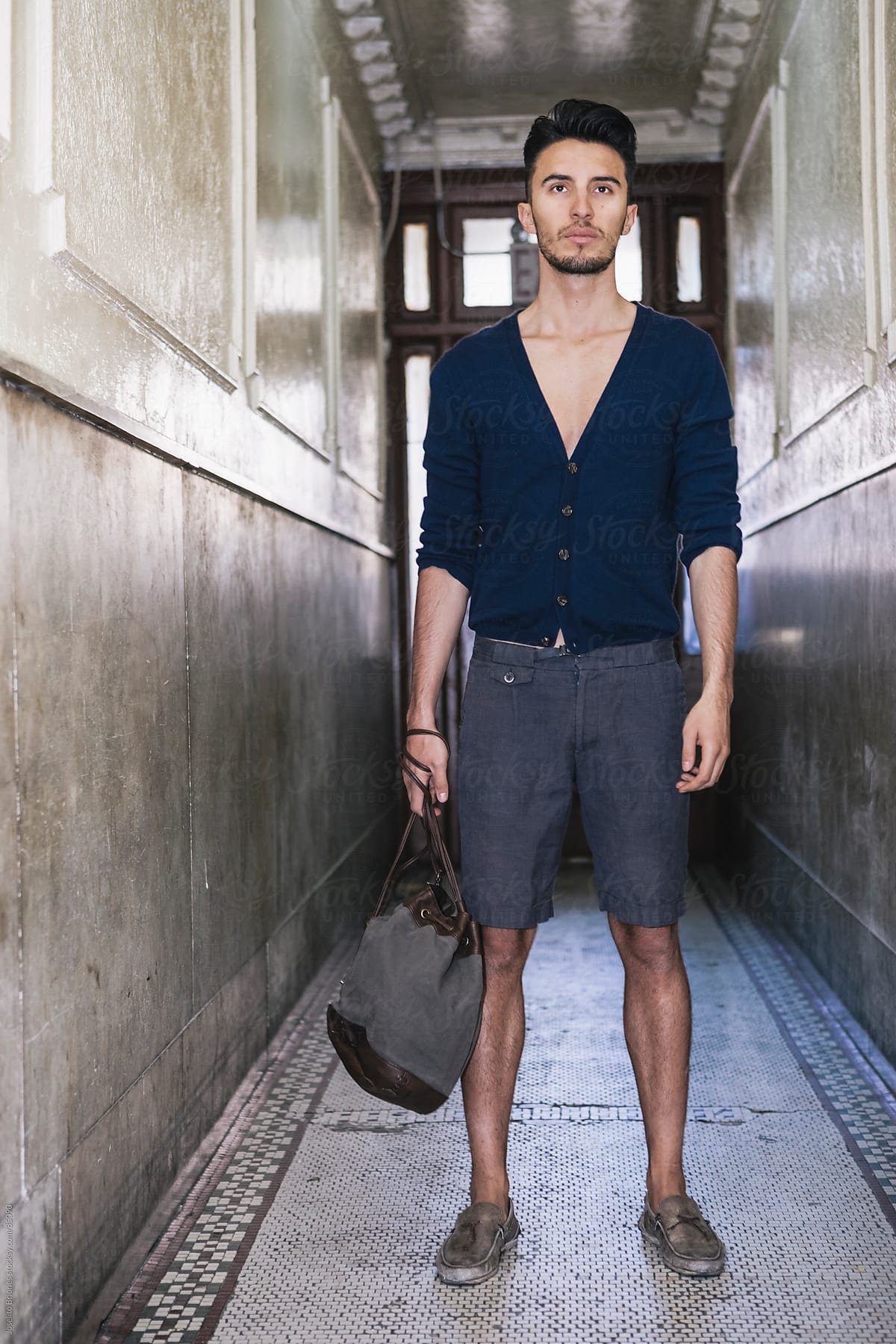 Young Man in Cardigan and Shorts Standing in Hallway