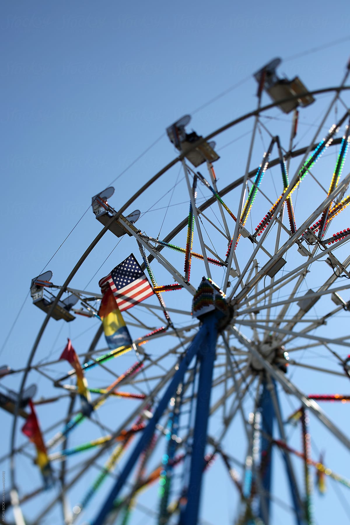 A Ferris Wheel Decorated With Flags On A Summer Day