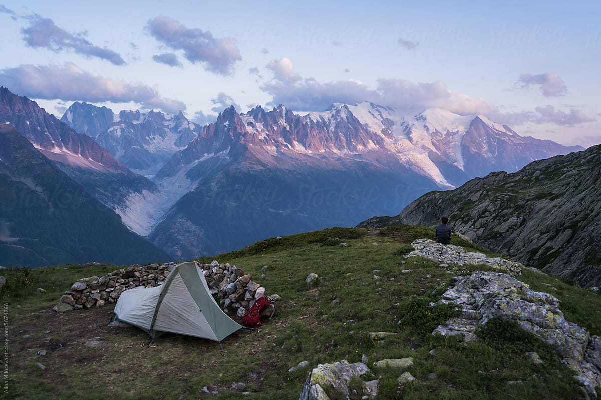 Hiker With Tent Camping Against Mountain Range