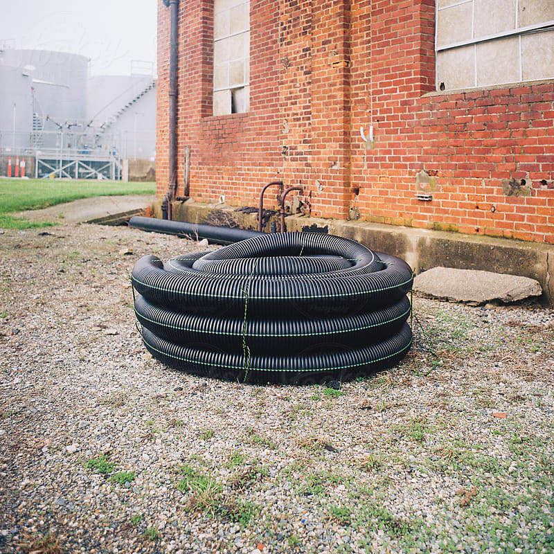 Spiraled plastic hose in front of brick building