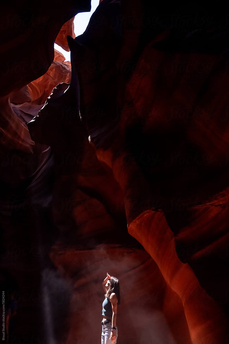 Woman looking up from the bottom of a narrow canyon in Arizona
