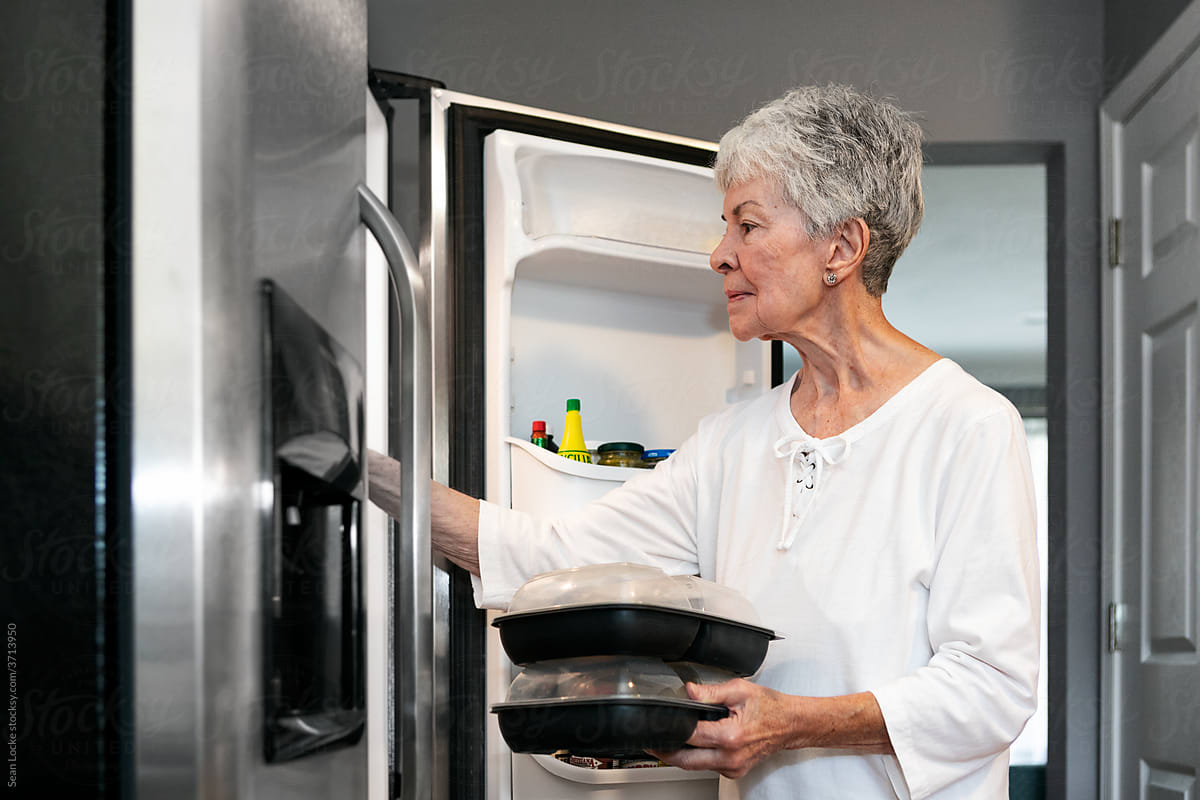 Meal: Senior Puts Delivered Meals Into Refrigerator