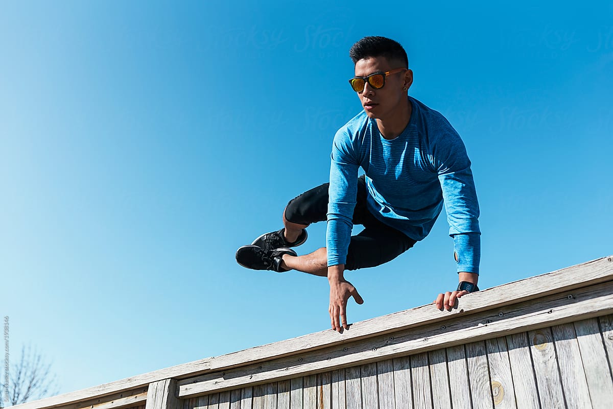 Young asian man practicing parkour in the city.