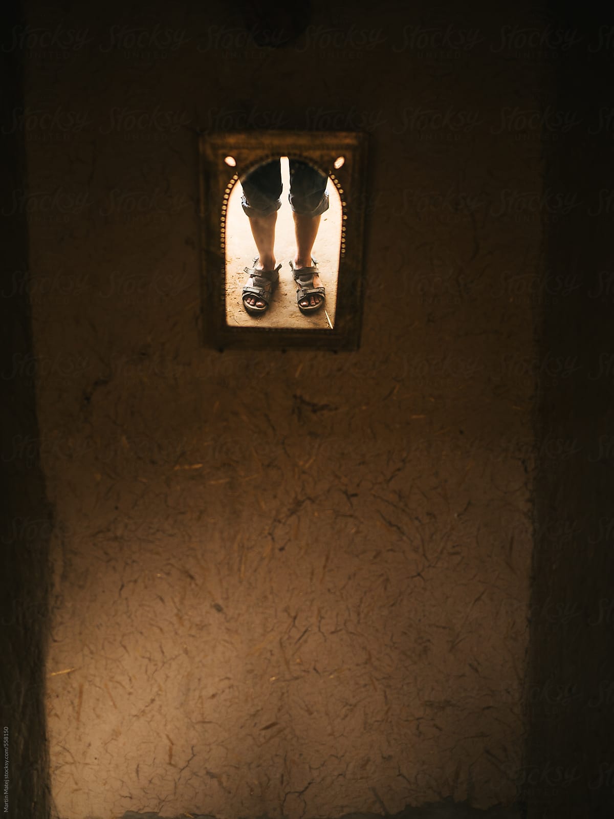 Reflection of sandals in small mirror in house made of mud