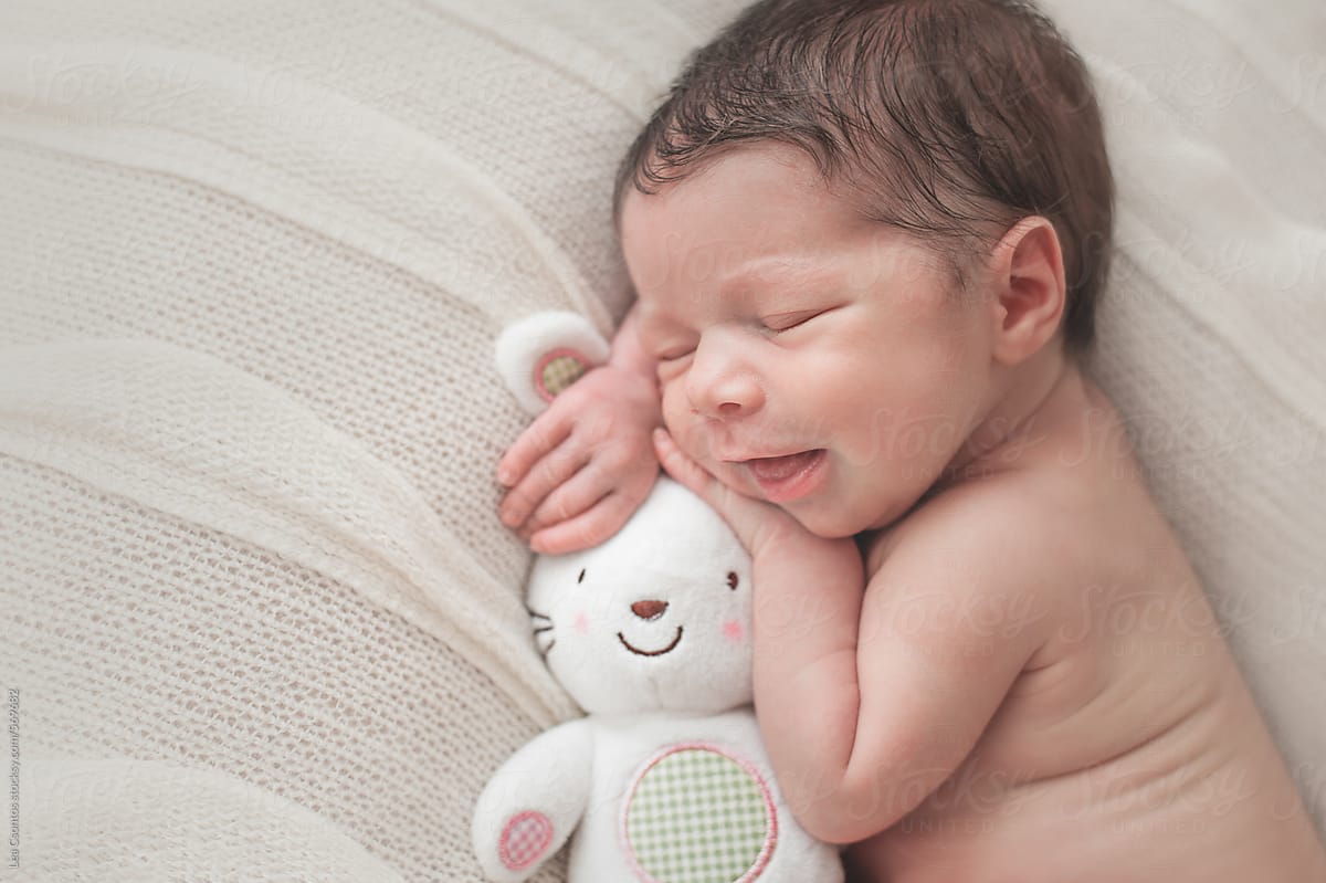  Smiling Newborn Baby Sleeping With A White Bunny Toy By Stocksy