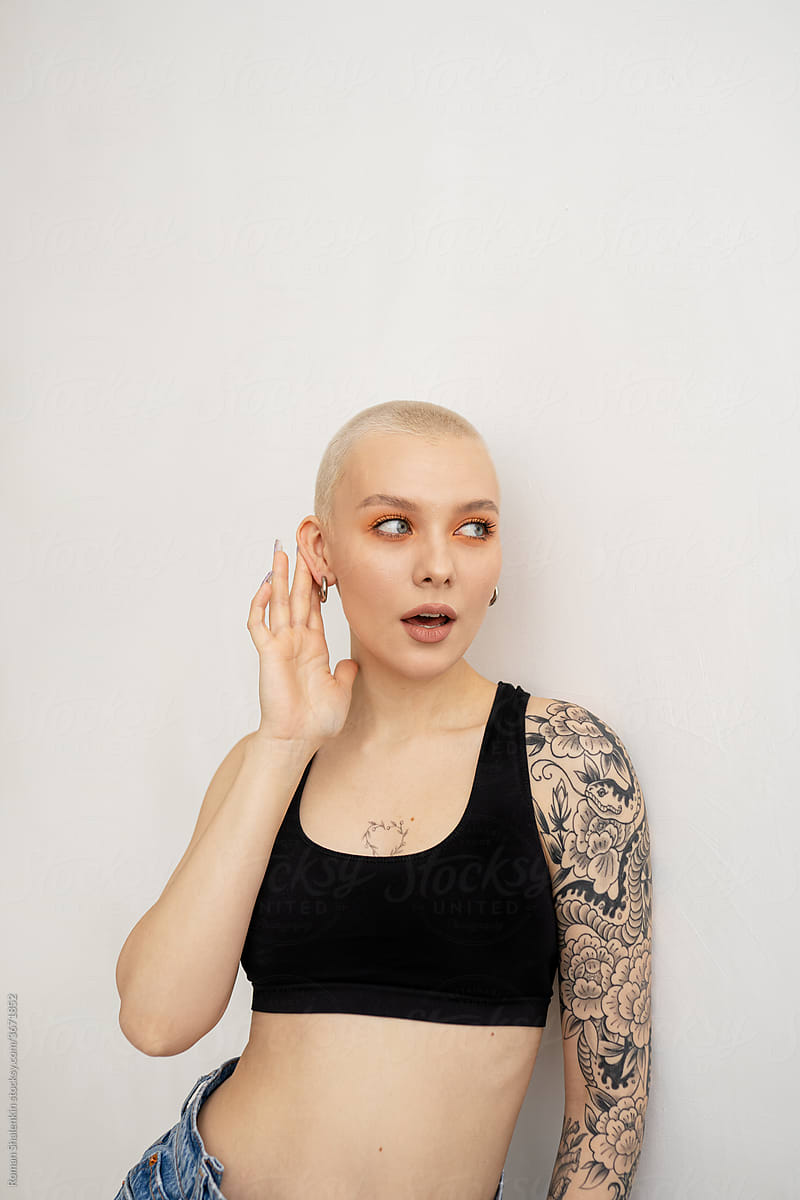 Young woman with short hair and tattoo  holding her hand