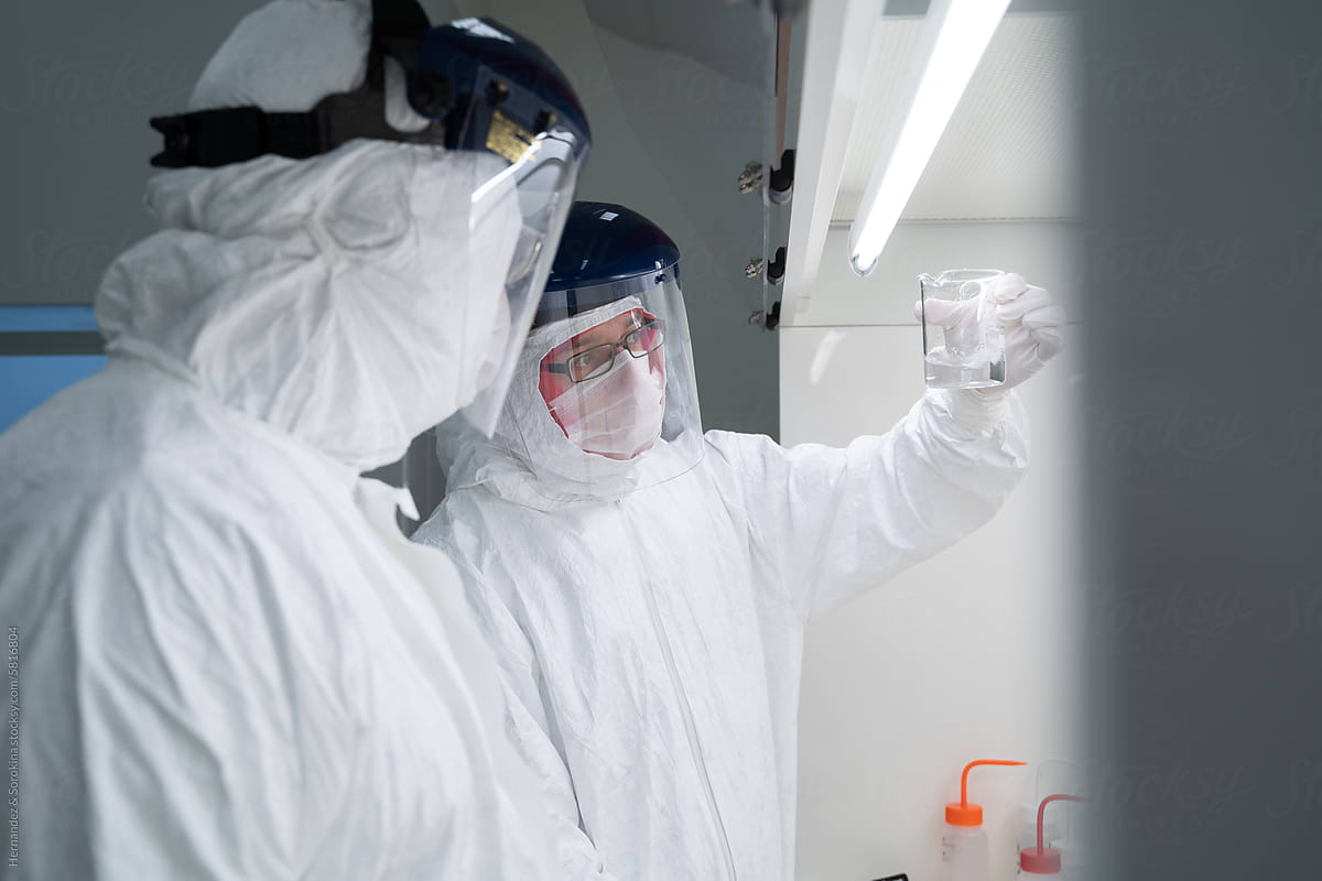 Two Researchers Working In Laboratory Chamber