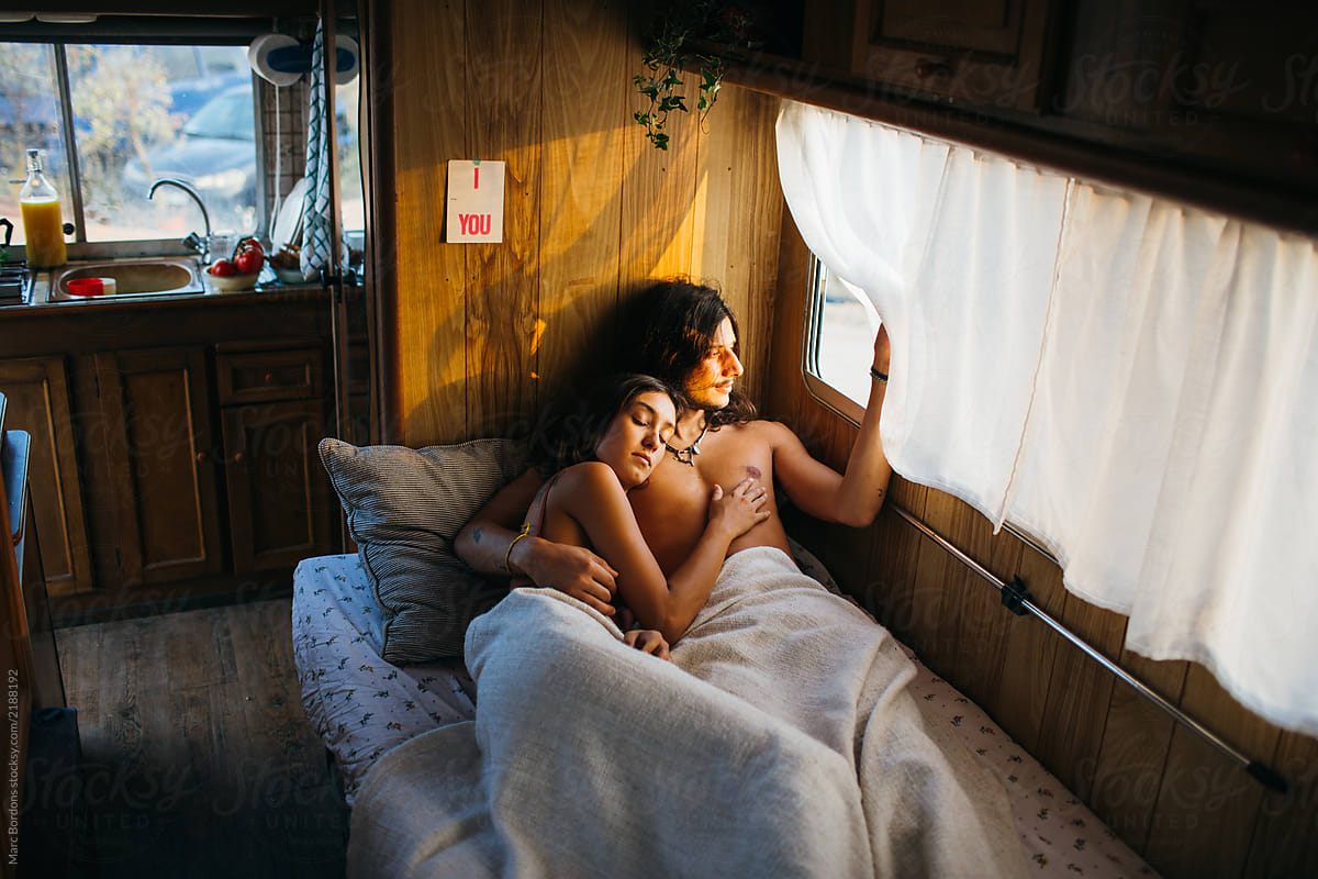 young couple waking up on the bed of motorhome