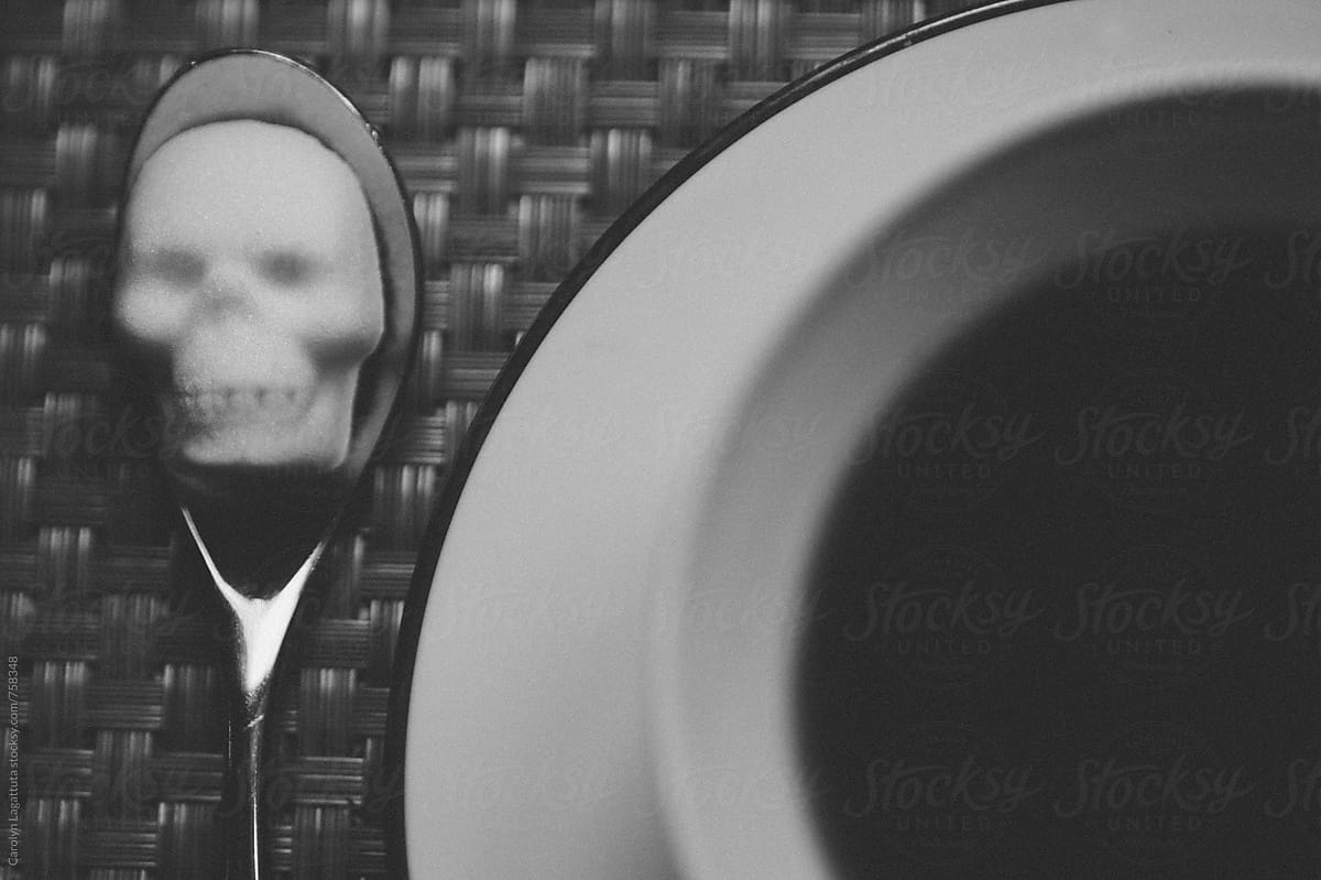 Black coffee with a sugar cube in the shape of a skull on a spoon