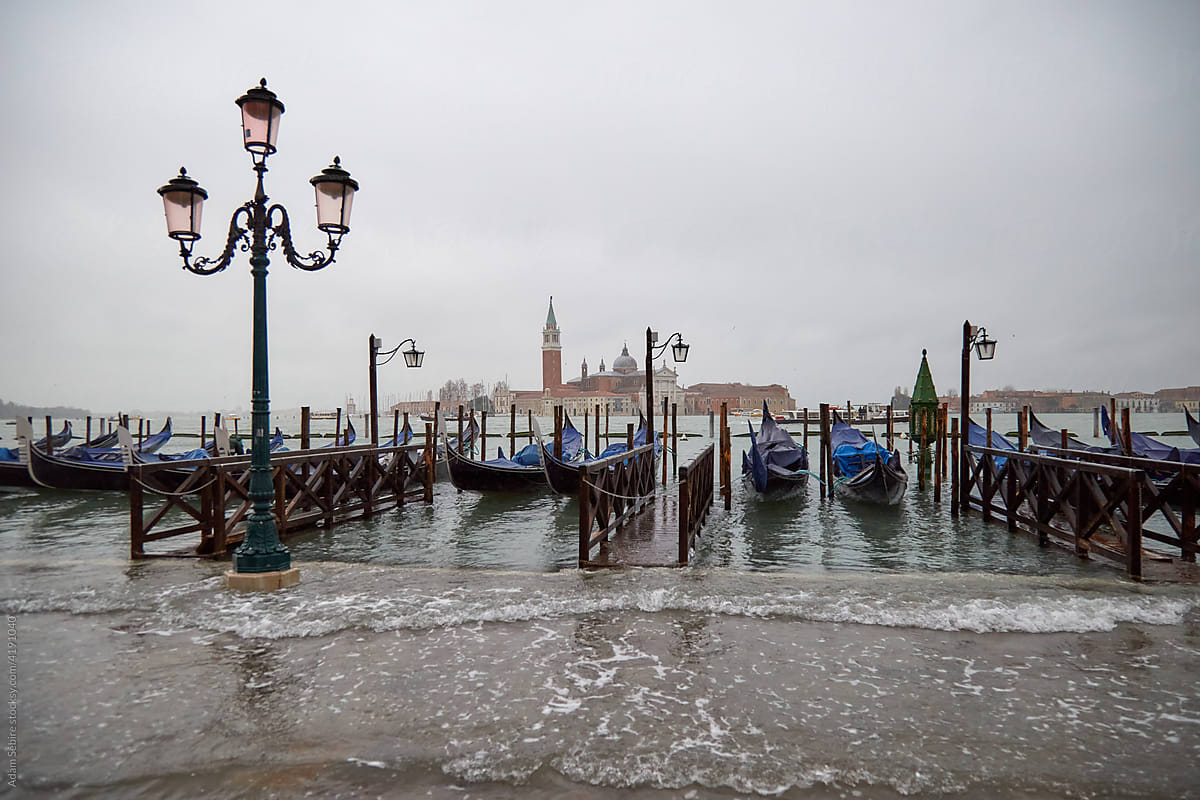 Venice gondolas as canal sea water washes in, high tide
