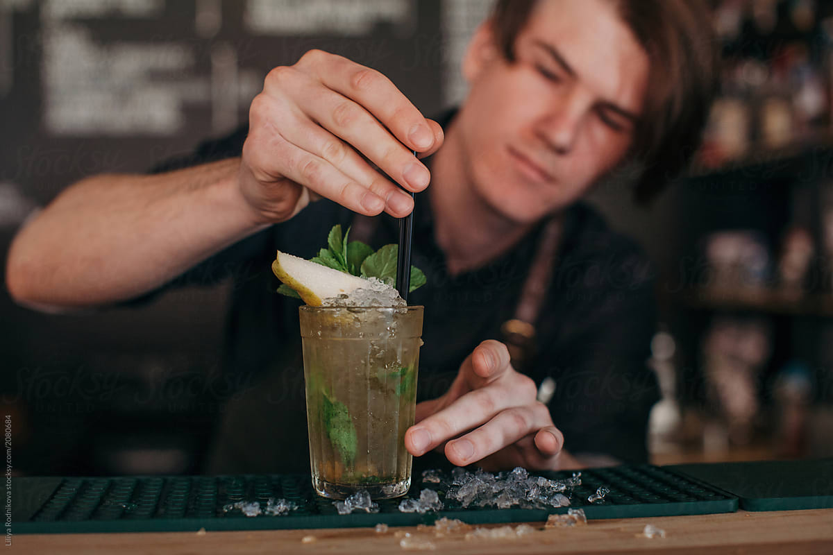 Barman add straw to the cocktail
