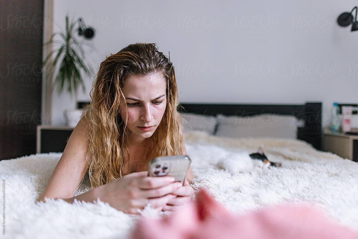 Young girl spending time in bedroom and using phone apps