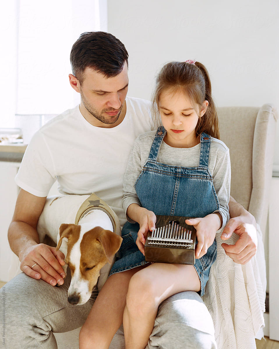 Dog near father and daughter with music box