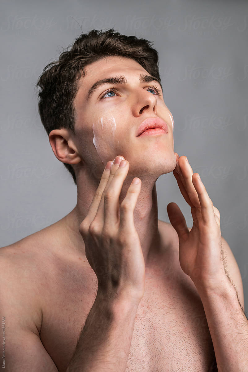Male skin care, man applying facial cream