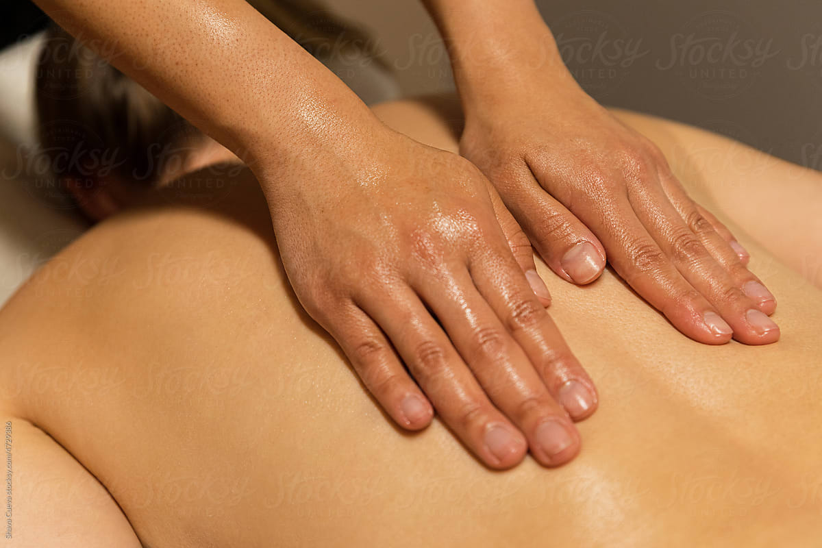 Woman\'s hands massaging a back at spa