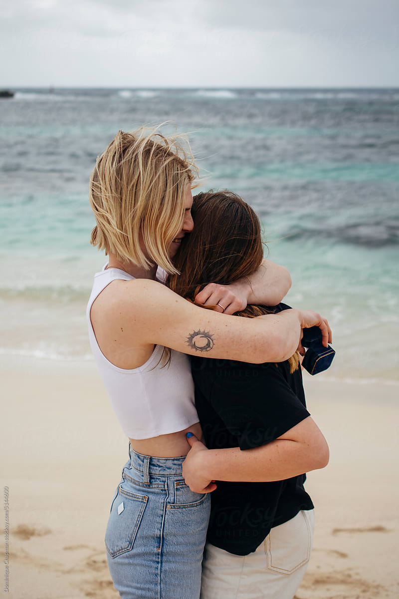Young Couple Holding Cuddling By The Beach/ photo
