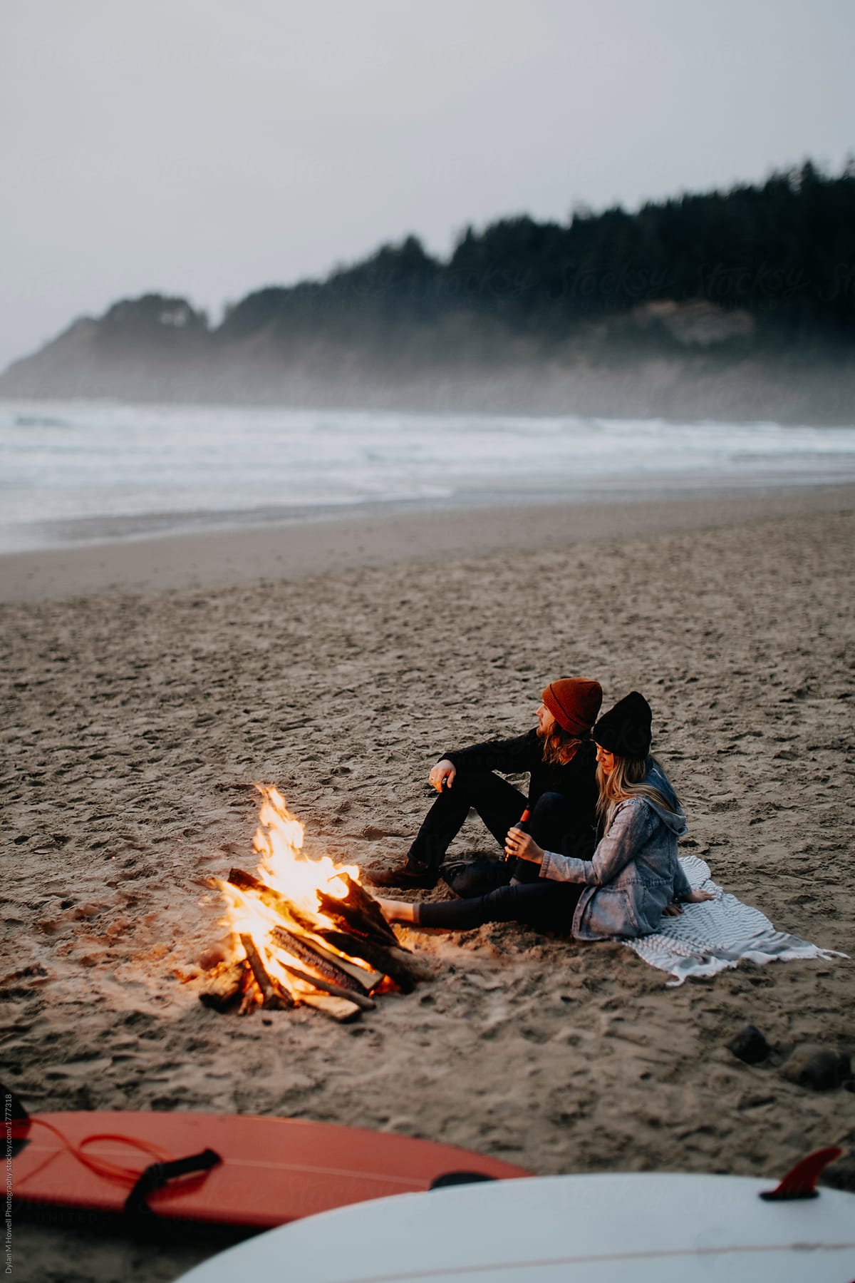 couple has a campfire after surfing
