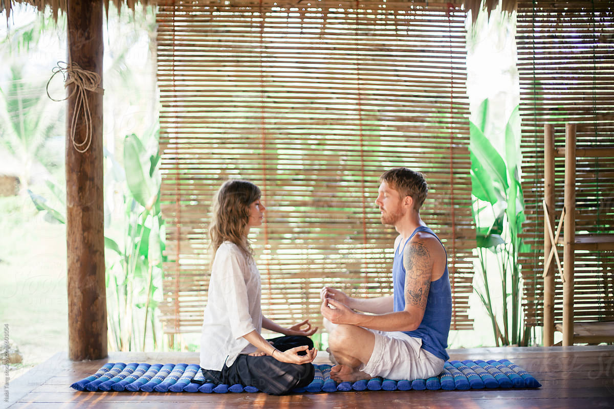 Couple meditate together in yoga retreat center