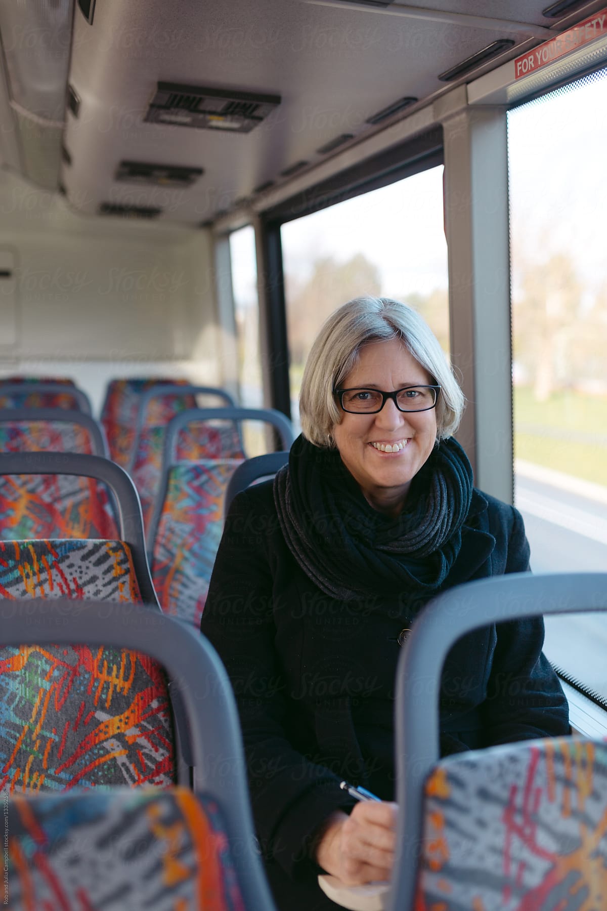 Mature caucasian woman playing sudoku on bus ride