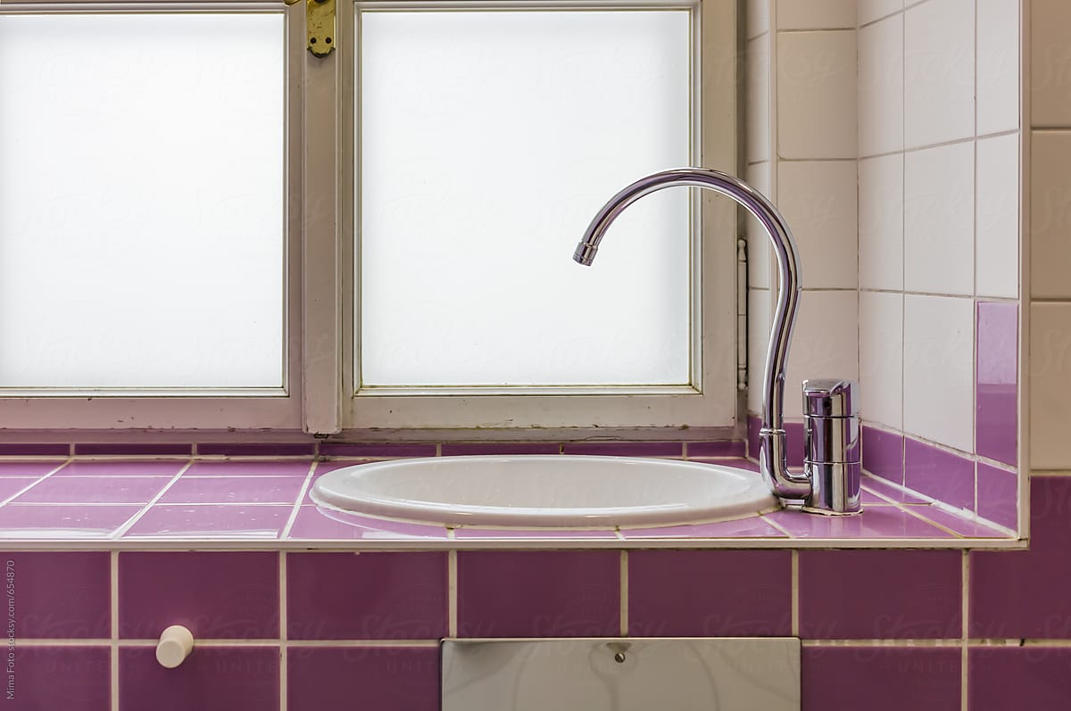 Curved faucet on pink wall