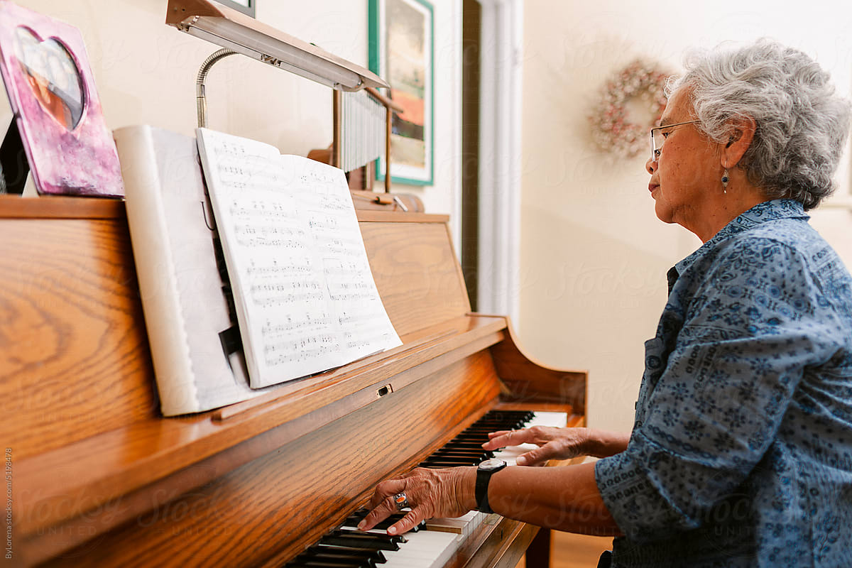 Mature woman playing the piano at home