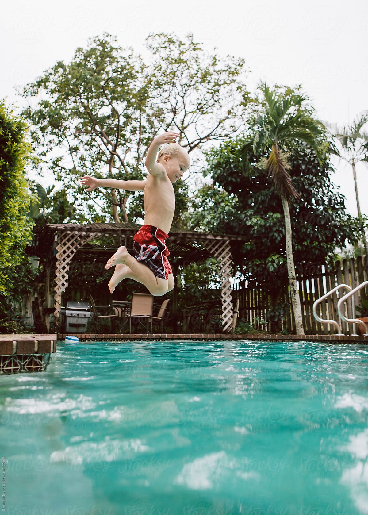 Boy jumping into pool