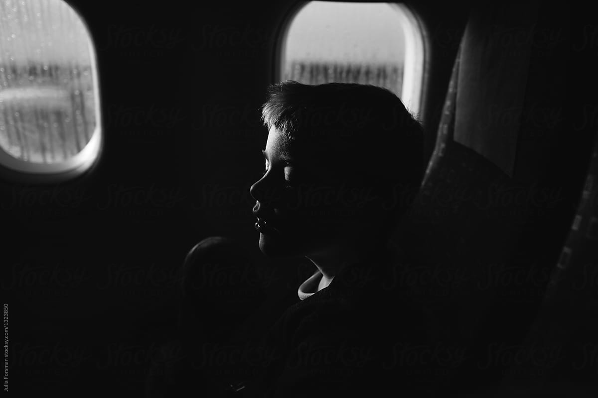 Boy with his eyes closed before an aeroplane takes off.