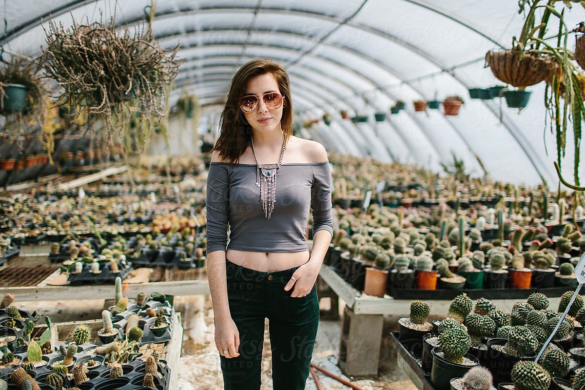 A woman standing in the middle of a cactus greenhouse
