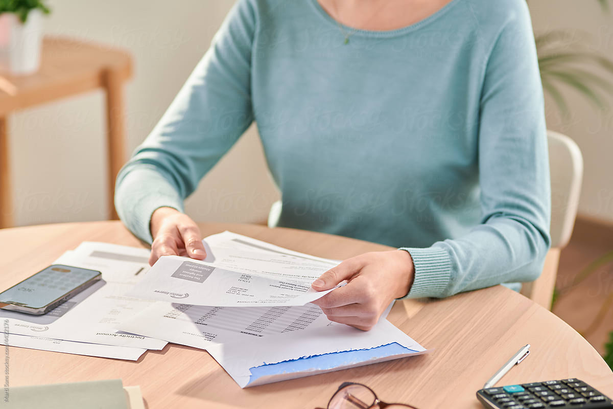 Woman paying bills and reading paper documents