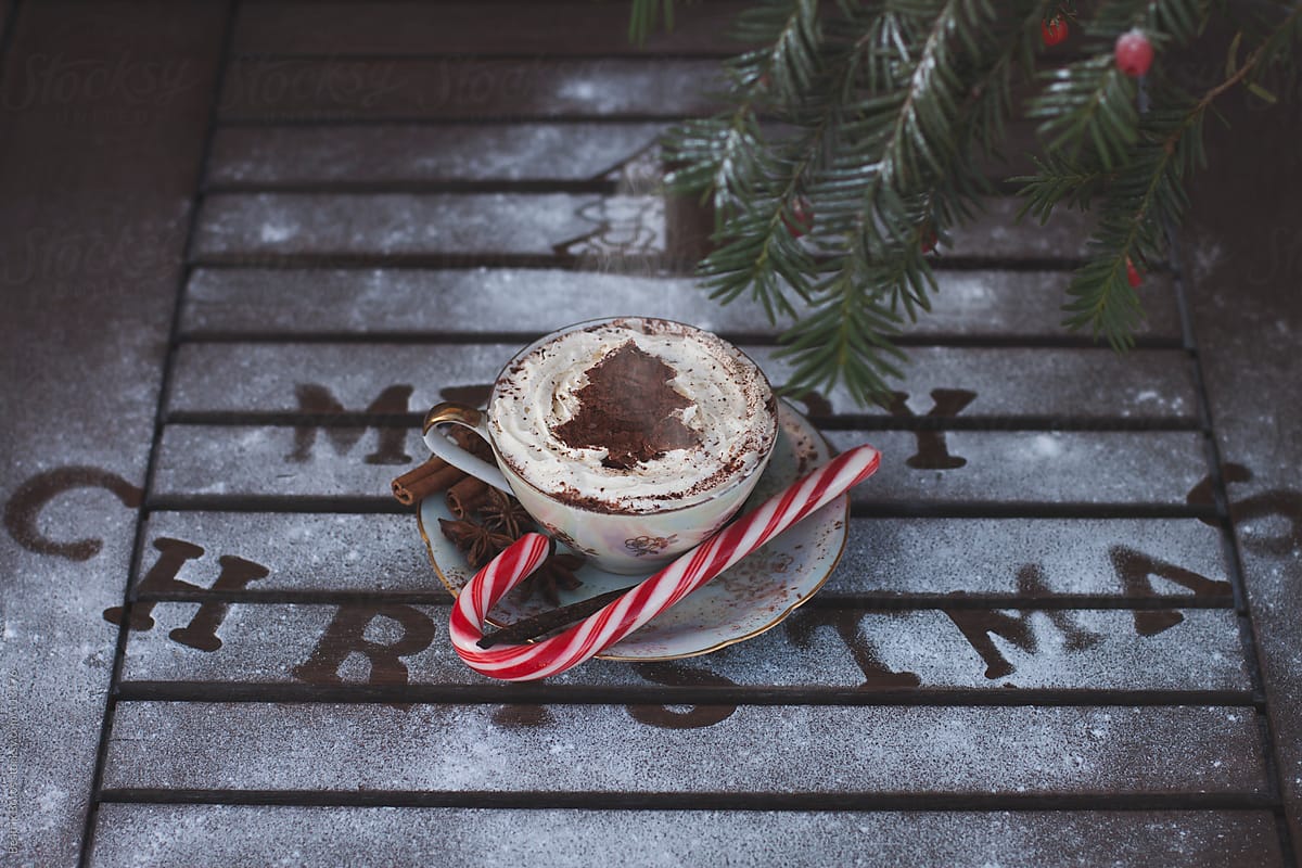 Hot chocolate with wipped cream for Christmas with decoration on a wooden table with fake snow