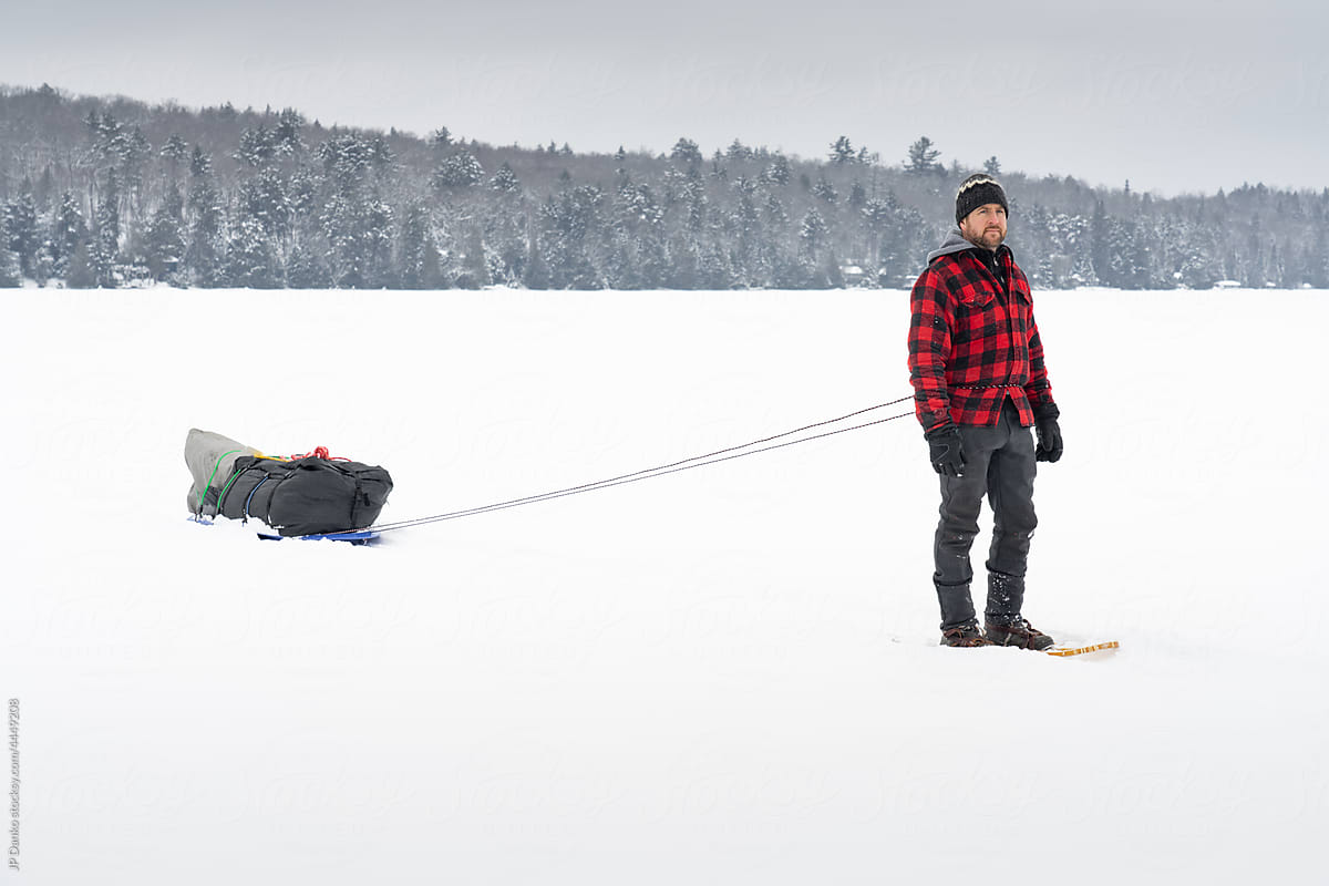 Snowshoeing with Winter Camping Sled on Snowy Lake