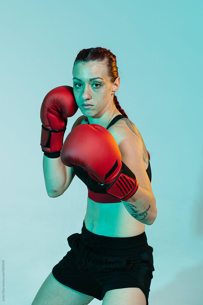 Athletic sportswoman in boxing gloves ready for fight