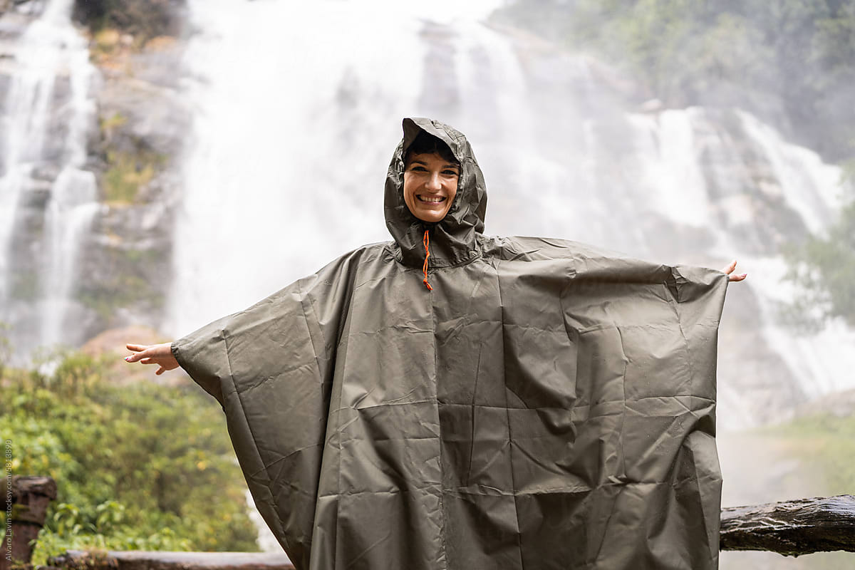 Woman smiling at the waterfall.