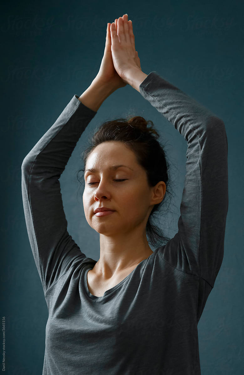 Woman meditating with raised arms