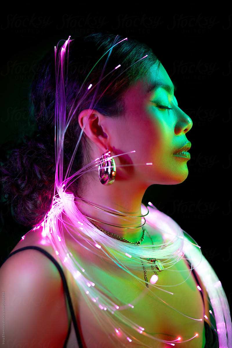 Serene Woman Surrounded by Neon Light Strands