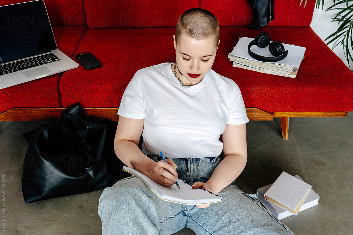 Shaved millennial doing learning at home sitting at floor