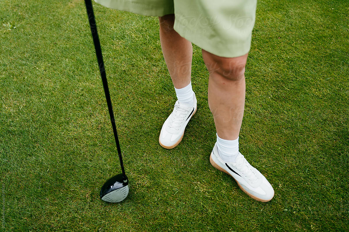 Women\'s legs and a golf club on the golf course