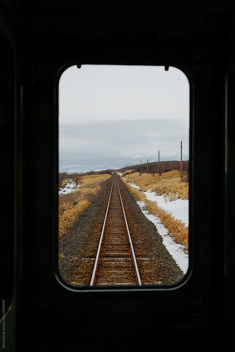 View of railroad tracks from the train window in winter, Hokkaido, Japan