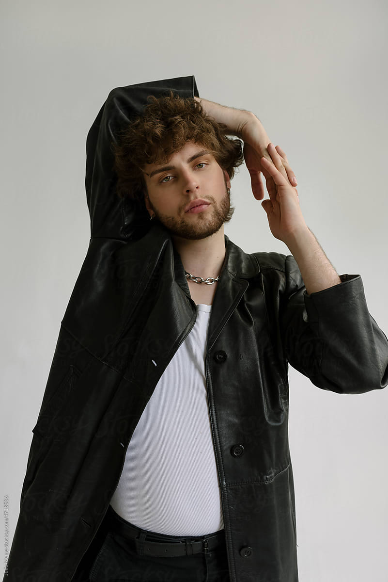 A bearded guy with curly hair in a  leather black coat