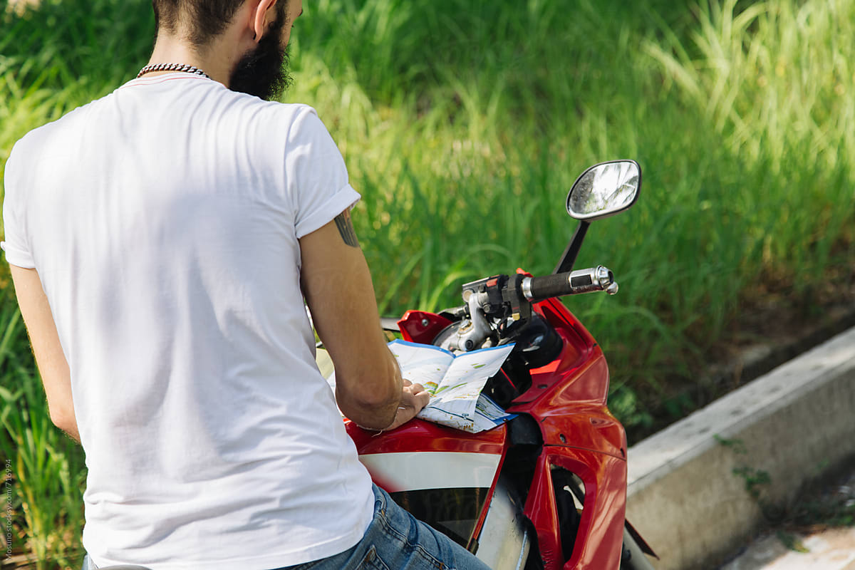 Man on a Motorbike Looking at the Map