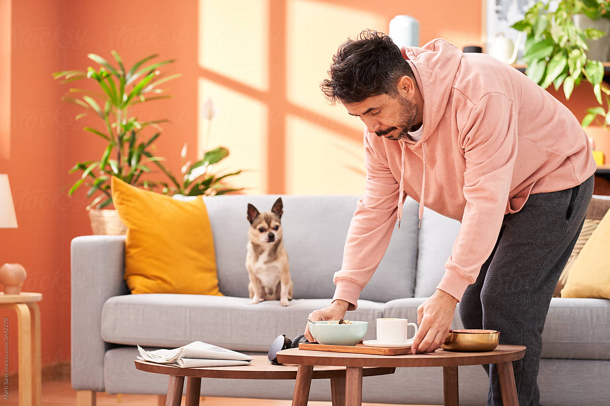Man going to have breakfast in living room with dog